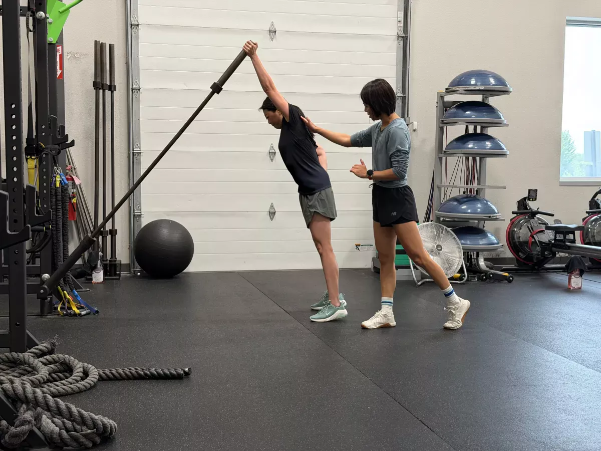 Bonnie guiding a client through a standing stretch